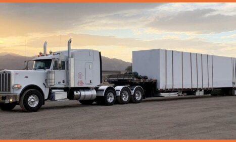Truck with a flatbed trailer and a load on top of it.