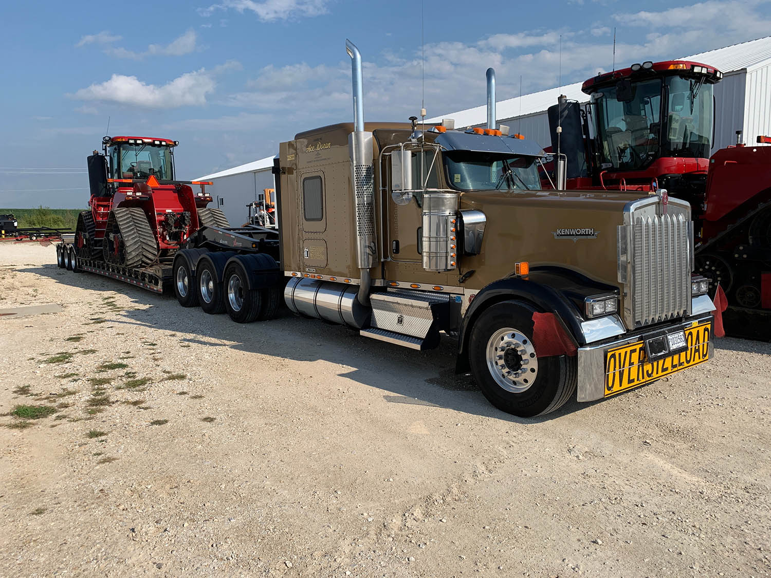 brown truck towing red machine